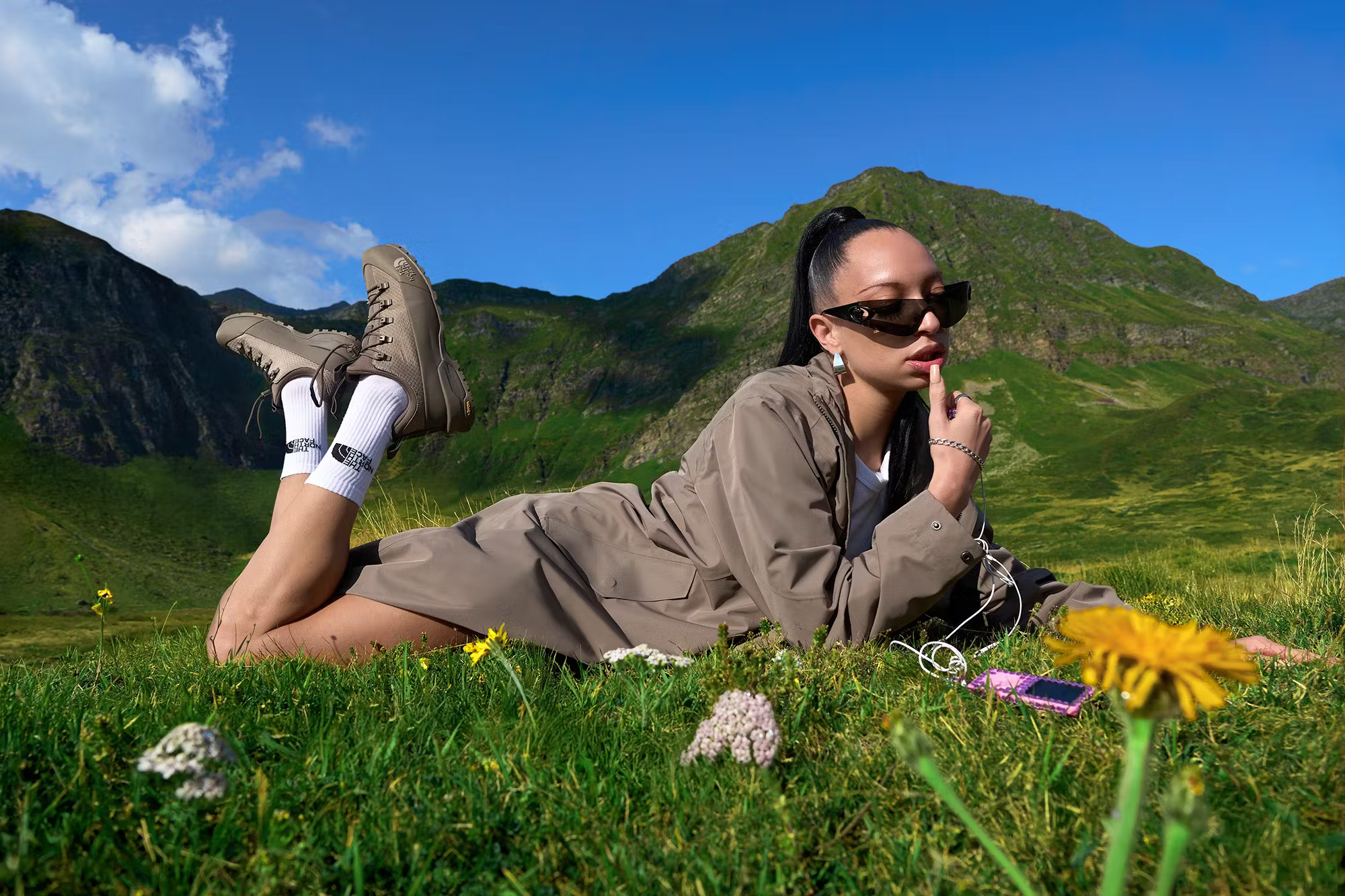 Image from the Touch Grass campaign by The North Face, with a girl lying on some grass.