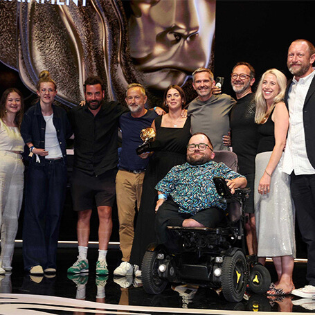 A group of marketing professionals on the stage at Cannes Lions, accepting a Grands Prix award for the Channel 4 campaign 'Considering What?'