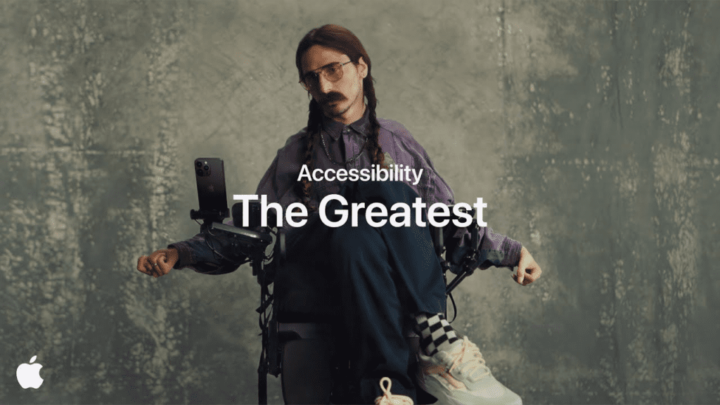 Image from the Apple's 'The Greatest' ad, showing a white person using their phone that is attached to their powered wheelchair.
