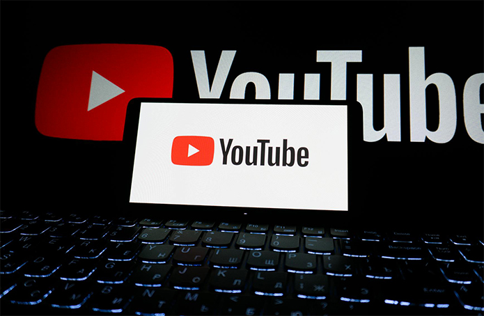 Phone on YouTube in front of a computer with YouTube on it.