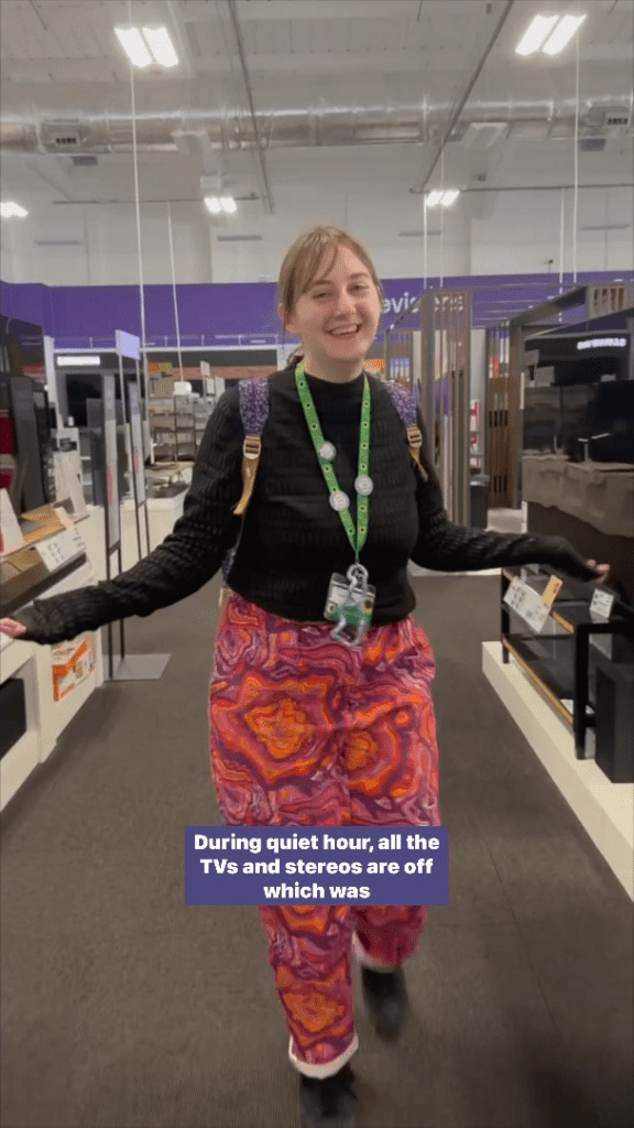 Screenshot of a woman walking through the aisle of a Currys store with her arms outstretched.