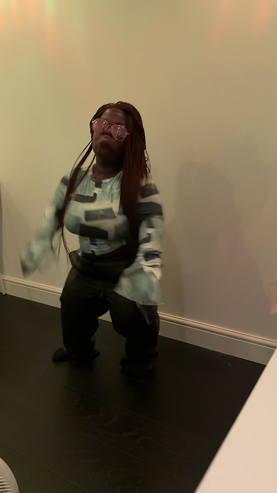Screenshot of a woman dancing in her living room.