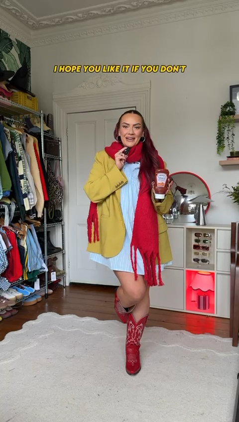 Emma stands in a bedroom filled with clothes. She is wearing a red and yellow outfit inspired by the new Heinz ketchup sweet sriracha flavour.