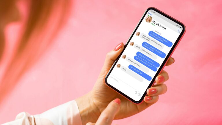 A mobile phone in a hand displaying a Facebook messenger conversation.
