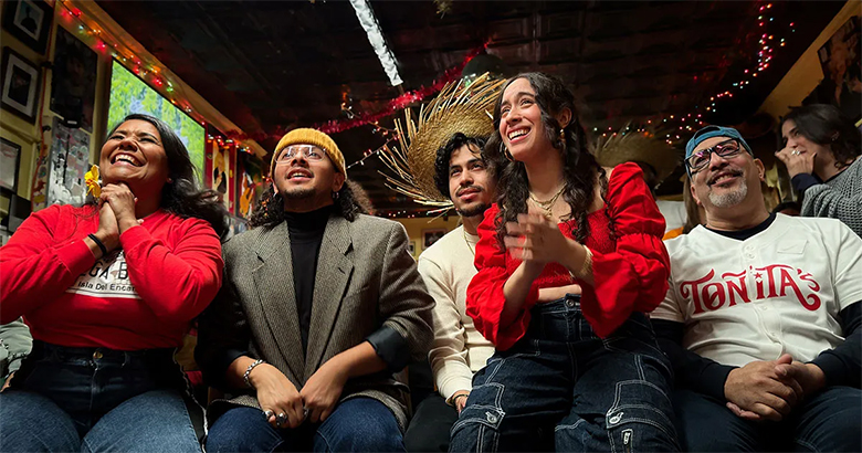 Photo captured on an iPhone of people proudly watching Bad Bunny's Halftime Show, feeling represented.