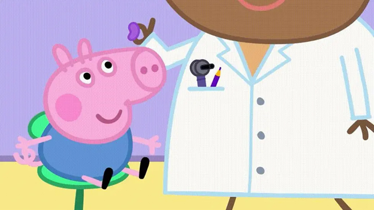 George, Peppa Pig's younger brother, being given a hearing aid by the doctor.