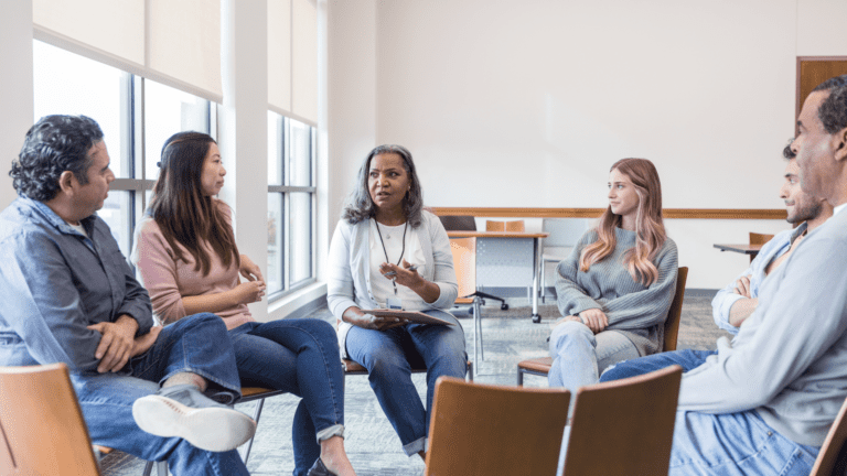 Five people sat on chairs in a circle discussing a topic as part of inclusive market research focus group.