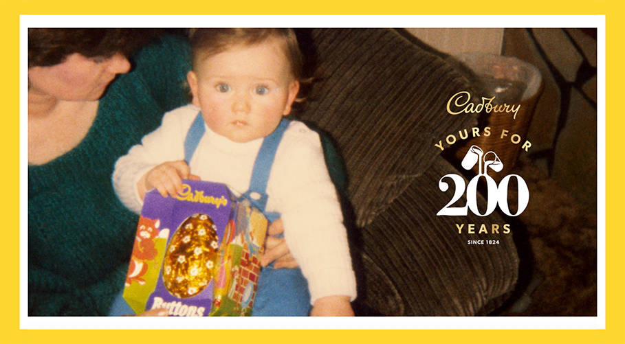 Image from the Cadbury's ad showing a picture from the 80s/90s where a toddler is holding a Cadbury's easter egg. On the right, the Cadbury's logo and 'Yours for 200 years'.