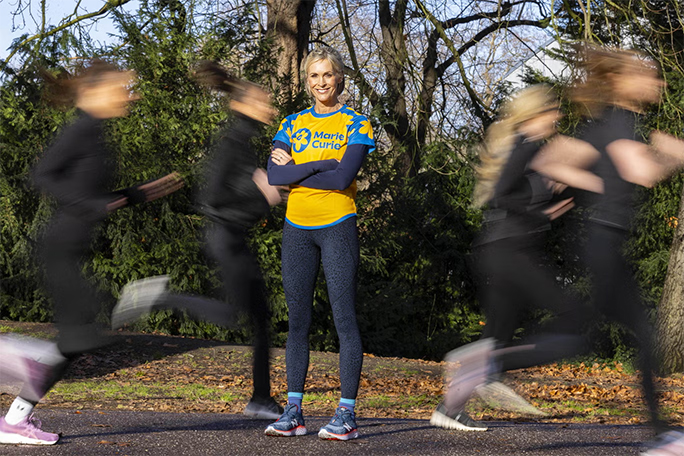 Jenni Falconer stands in Battersea Park among runners attending the Marie Curie Grief Run Club.