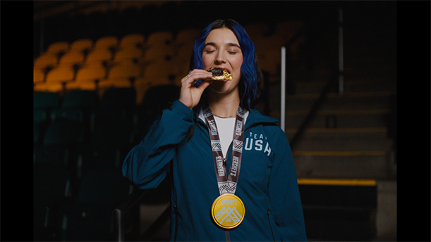 Brenna Huckaby, part of the Team USA Para Snowboarding team, eating Hershey's chocolate in an ice rink.