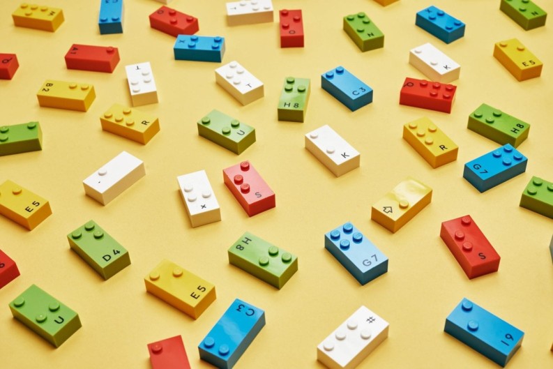 The LEGO braille bricks including colours blue, yellow, red, green and white, with braille on them.