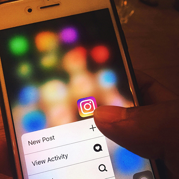 Someone focusing on the Instagram app icon on their phone.