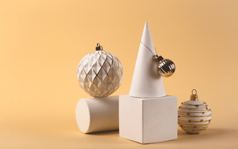 Shapes and white Christmas baubles in a neutral product photo setup.