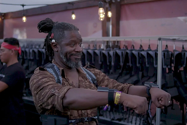 Deaf man wearing a vest that vibrates alongside music being played so the user can feel the music at a concert.