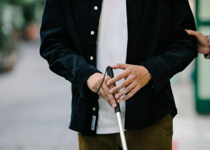 Body shot of a person holding a cane. 