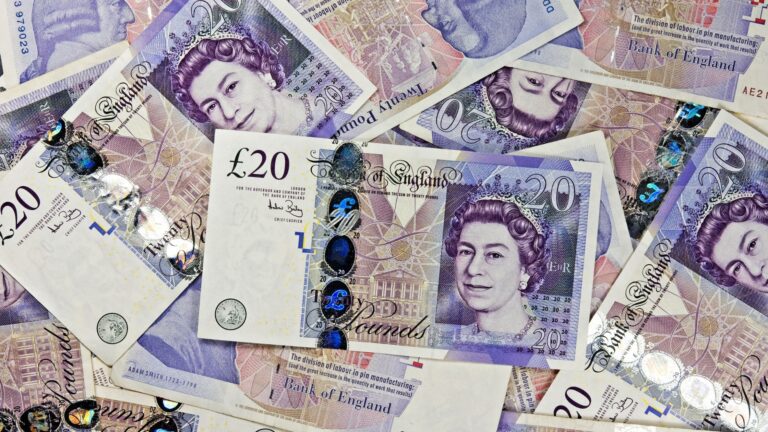 Purple £20 notes spread flat across the width of the photo.