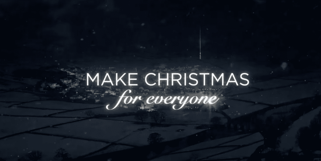 A screenshot from the Dunnes Stores' Christmas advert. In the background a city/town at night full of lights, in the centre a text that says 'Make Christmas for everyone'.