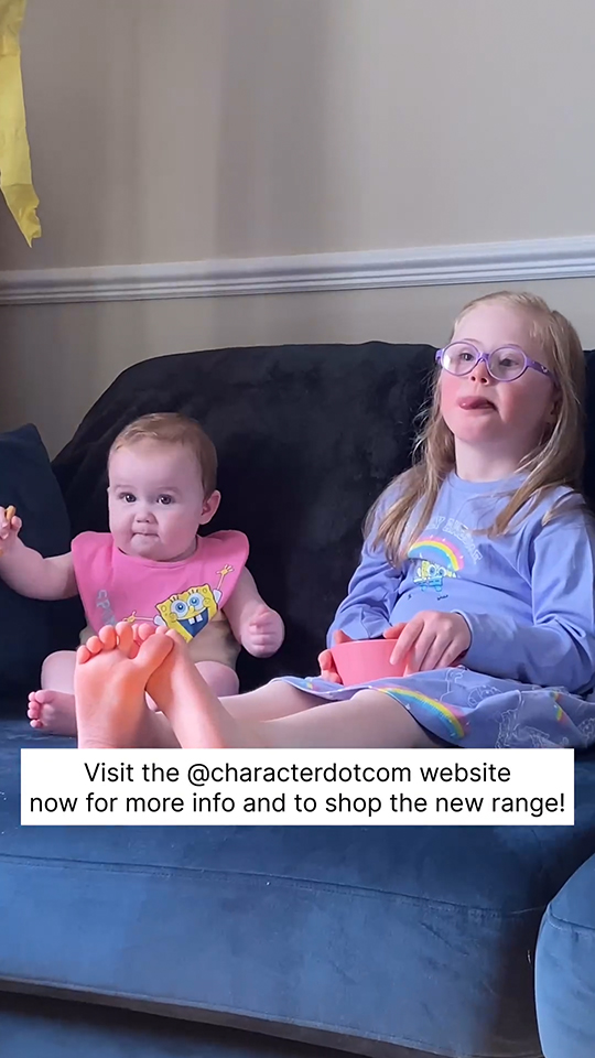 For Paramount campaign, two young girls sit on the sofa watching TV while wearing Spongebob adaptive wear. Caption on screen reads: "Visit the @characterdotcom website now for more info and to shop the new range!"
