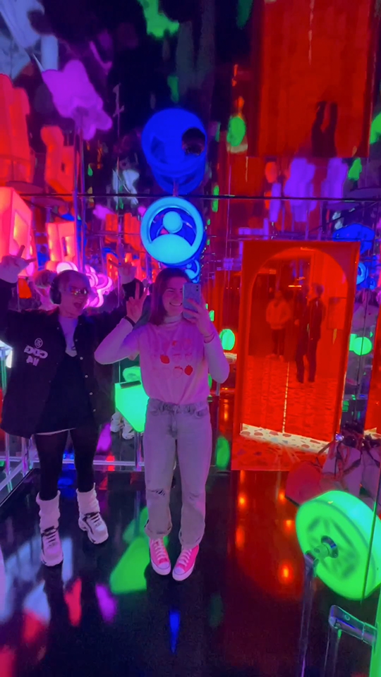 Zara and her friend are in a neon illuminated dark room at Virgin Media's Gamepad location.
