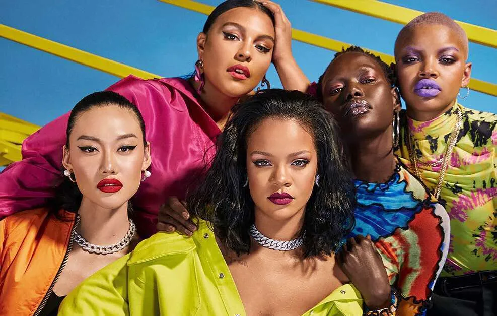 A group of women from different ethnicities are posing together, in the centre, Rihanna, a black woman with dark hair.