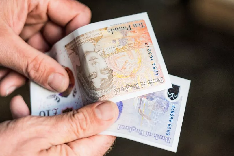 An image of some hands holding some pound notes. 