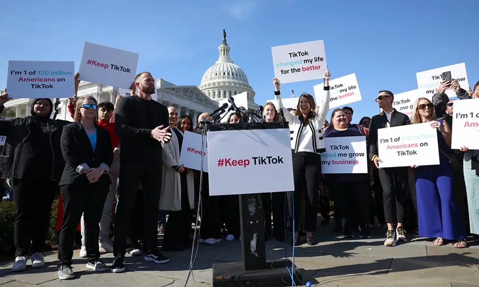A group of people stand outside the White House with signs like "TikTok changed my life" and "I'm 1 of 170 million Americans on TikTok".
