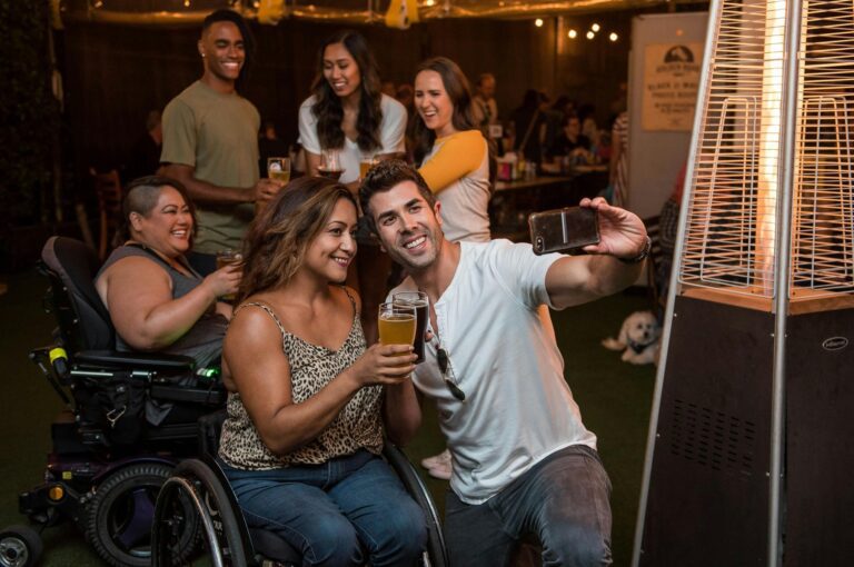 A diverse group of people are in a bar taking a picture together.