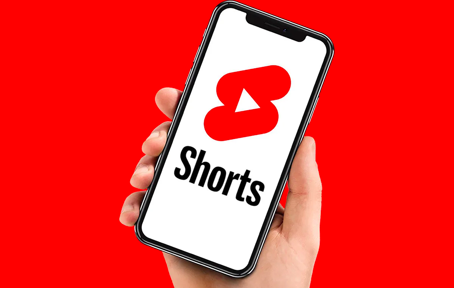 Someone holding a phone with the YouTube Shorts logo on it.